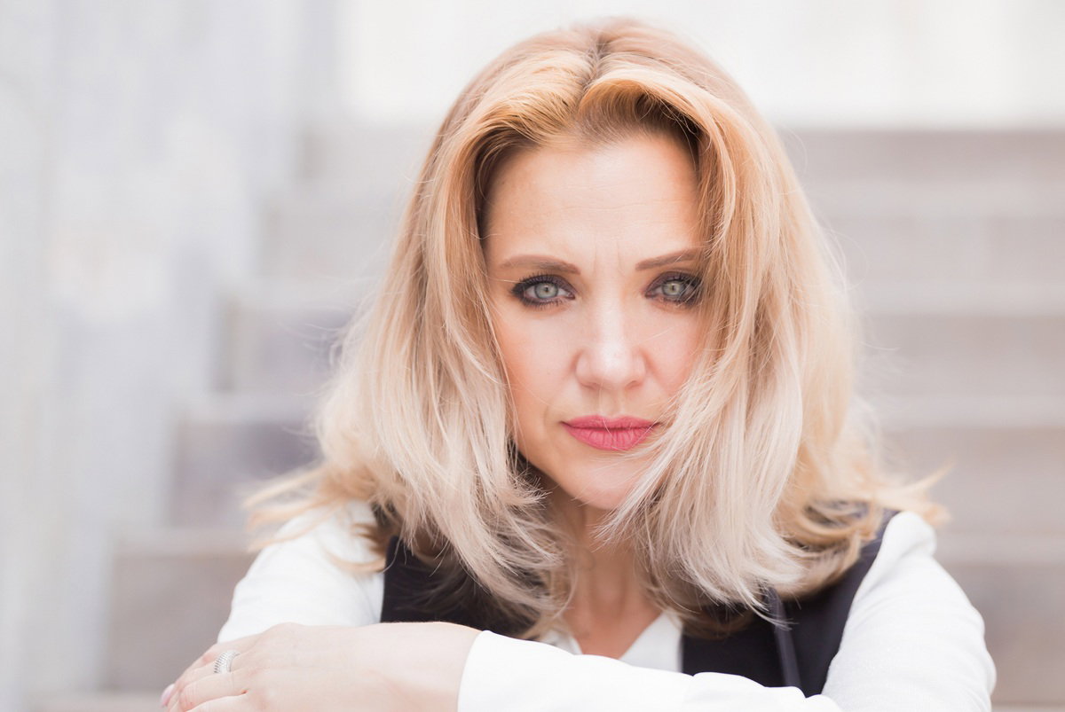 kobieta w wieku 30 plus blondynka siedzi na schodach ze łzami w oczach