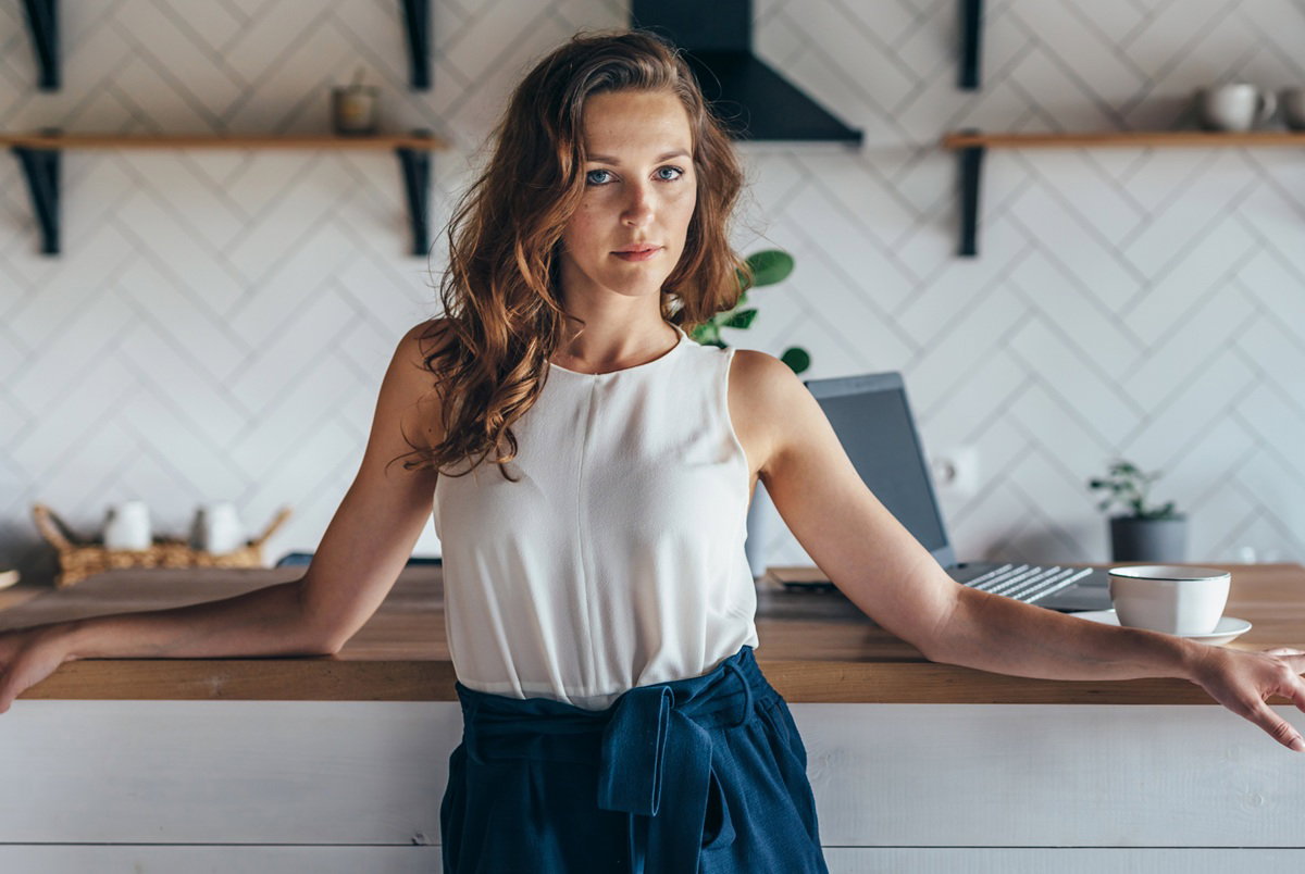 kobieta w wieku 30 plus stoi w kuchni zdenerwowana i dumna