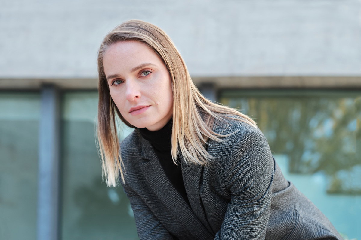 kobieta w wieku 30 plus blondynka w marynarce stoi na zewnątrz smutna i zamyślona