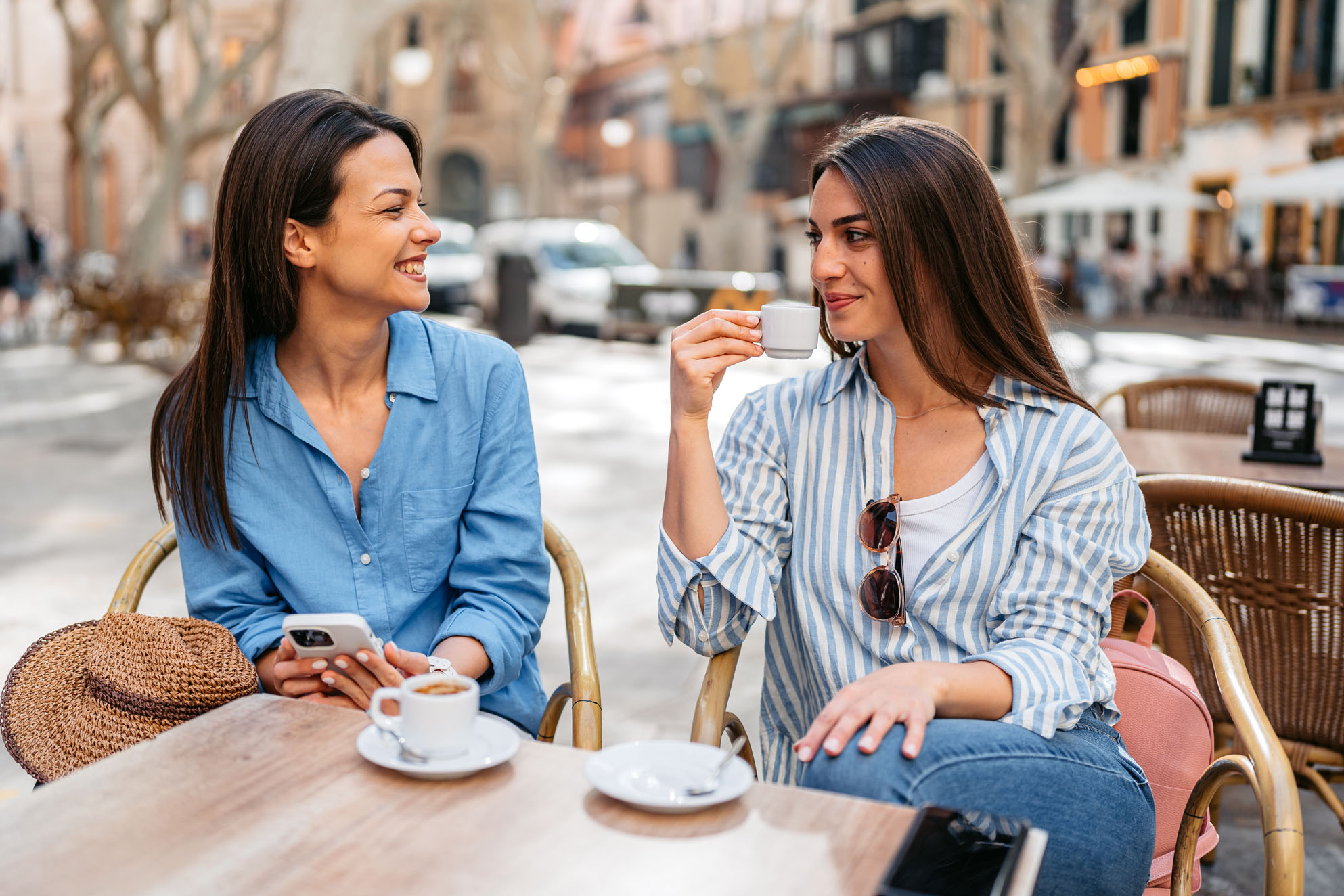 Two Female Friends Drinking Coffee In A Sidewalk Café In Palma De Mallorca In Spain