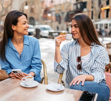 Two Female Friends Drinking Coffee In A Sidewalk Café In Palma De Mallorca In Spain