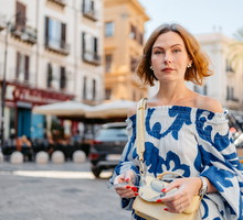 kobieta w wieku 35 plus we wzorzystej sukience stoi smutna w Palermo na Sycylii we Włoszech