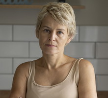 kobieta w wieku 45 plus blondynka stoi na tle kuchni zmartwiona