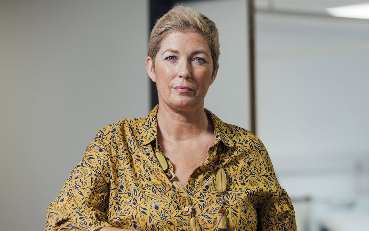 kobieta w wieku 45 plus krótkie włosy siedzi w biurze z poważną miną