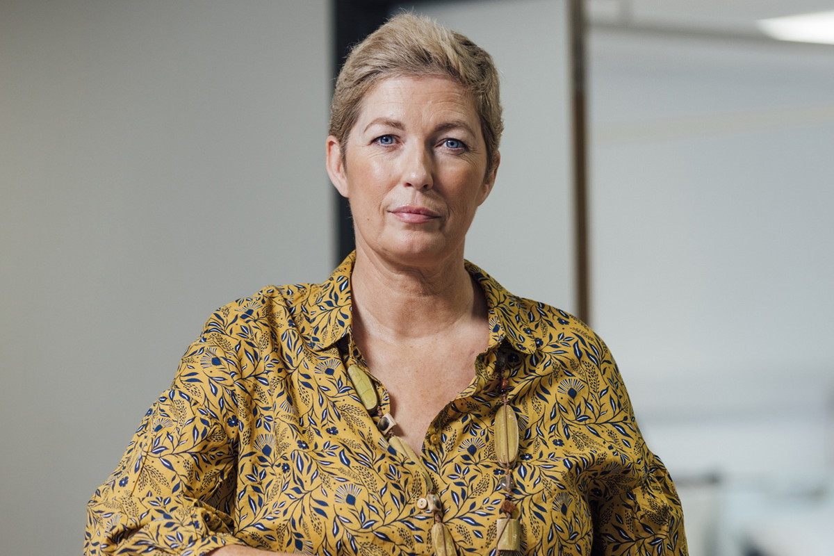 kobieta w wieku 45 plus krótkie włosy siedzi w biurze z poważną miną