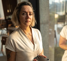 kobieta w wieku 45 plus stoi na zewnątrz z telefonem w dłoni