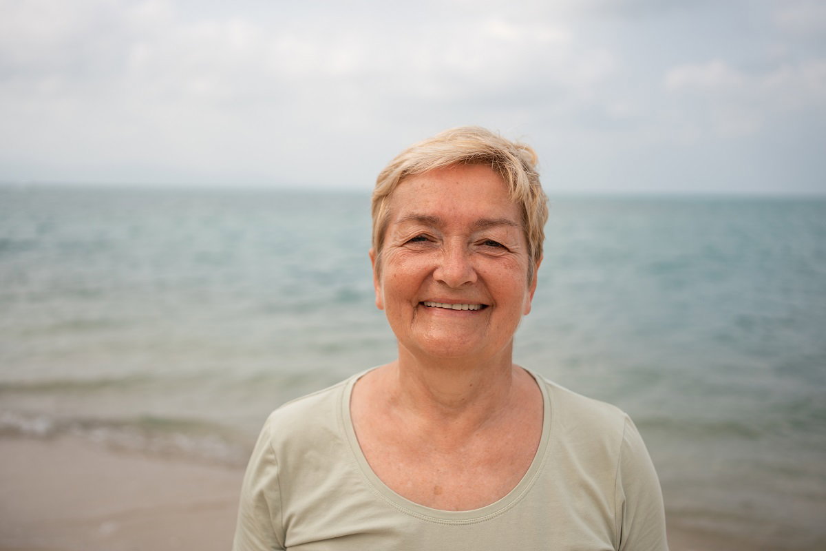 uśmiechnięta seniorka nad morzem