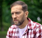 Zamyślony mężczyzna na tle drzew