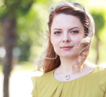 kobieta w wieku 30 plus blondynka w żółtej sukience stoi na ulicy z poważną miną