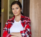 kobieta w wieku 30 plus z ciemnymi włosami w kraciastej koszuli stoi w markecie budowlanym zdenerwowana