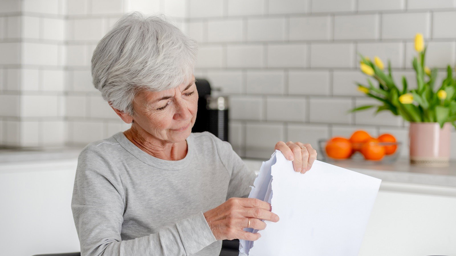 seniorka otwierająca kopertę