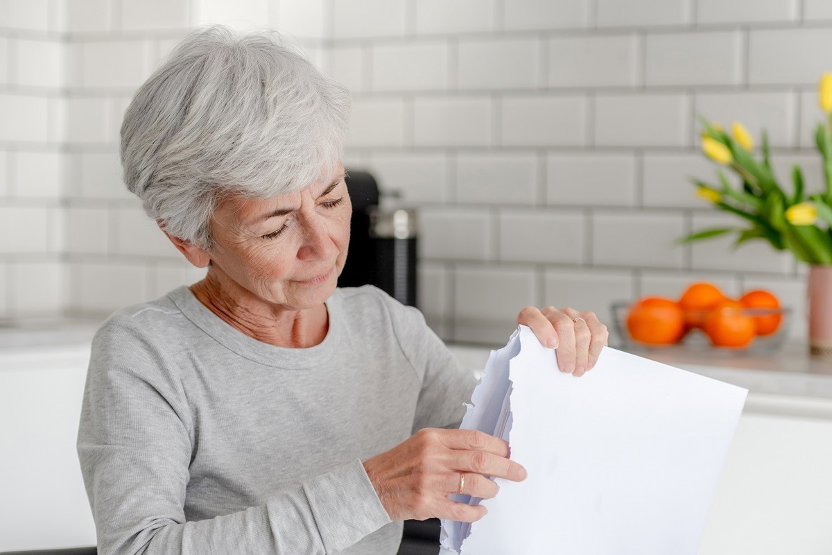 seniorka otwierająca kopertę