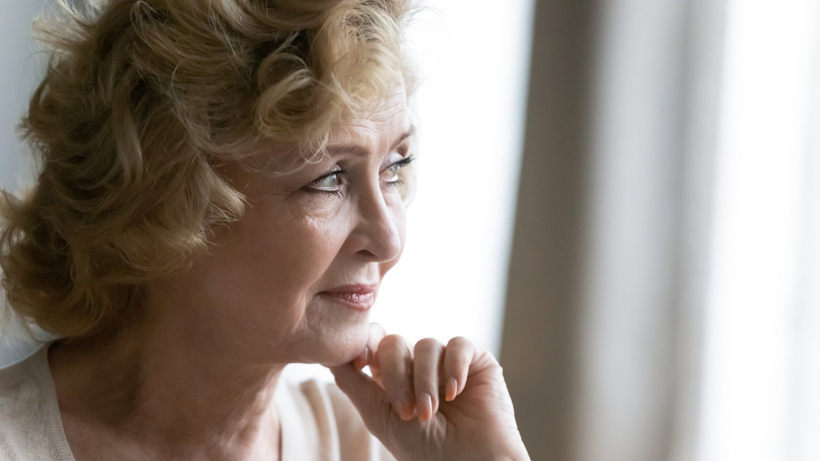 zamyślona seniorka w salonie