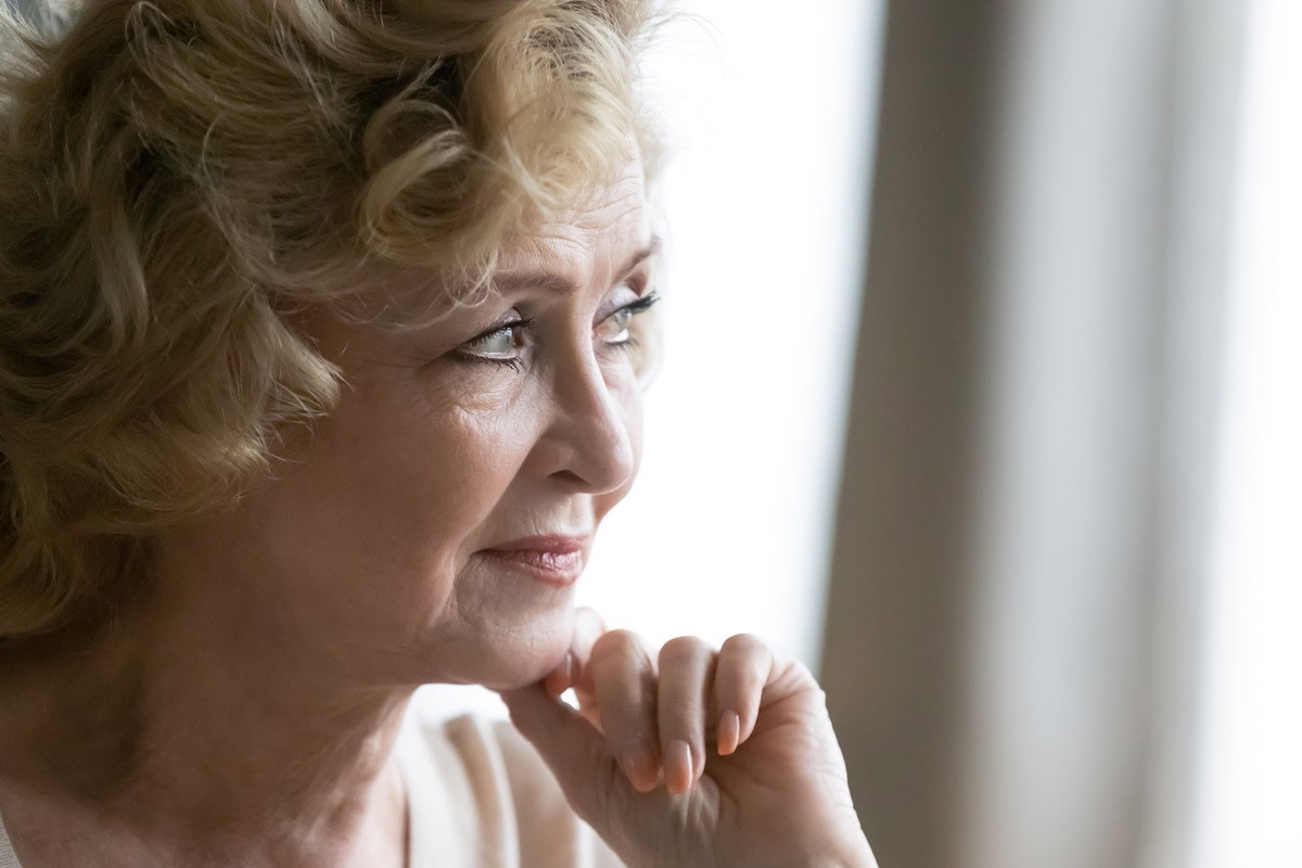 zamyślona seniorka w salonie