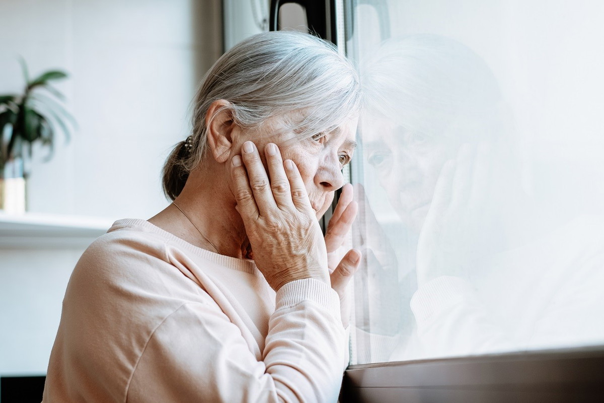 zmartwiona seniorka w oknie