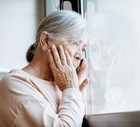 zmartwiona seniorka w oknie
