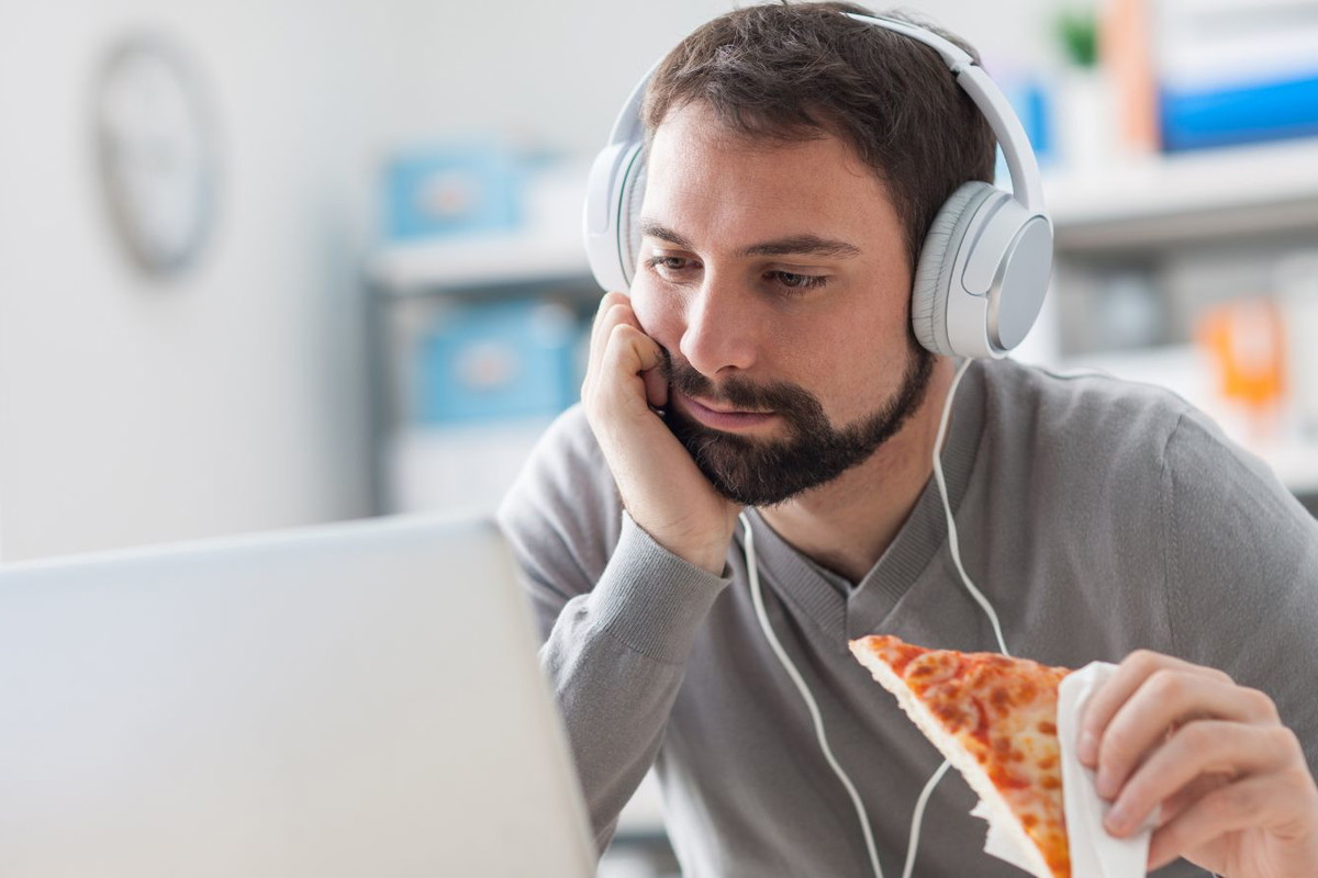 mężczyzna jedzący pizzę