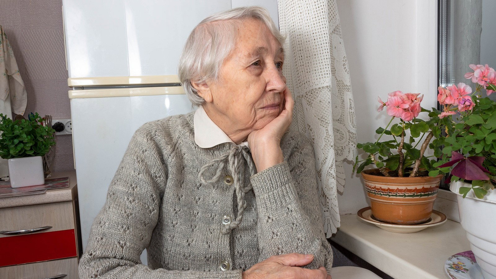 smutna seniorka przy oknie