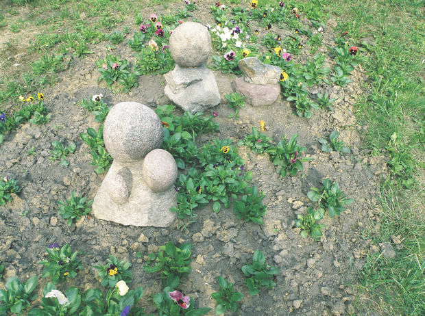 Kamienne ludziki zdobią grządki