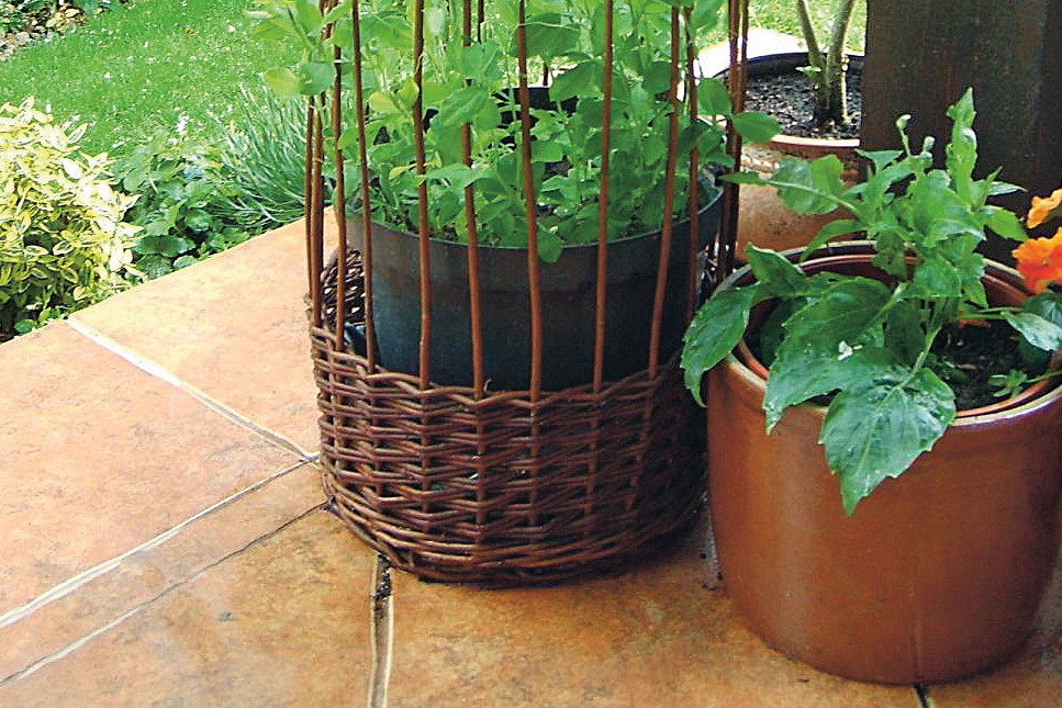 Oryginalny kształt wiklinowej osłony na donicę od razu przykuwa uwagę