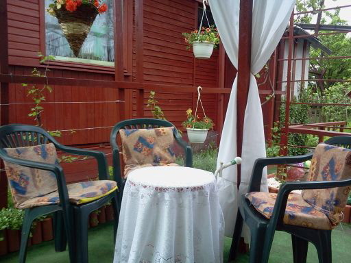 Kącik na odpoczynek pod pergolą .