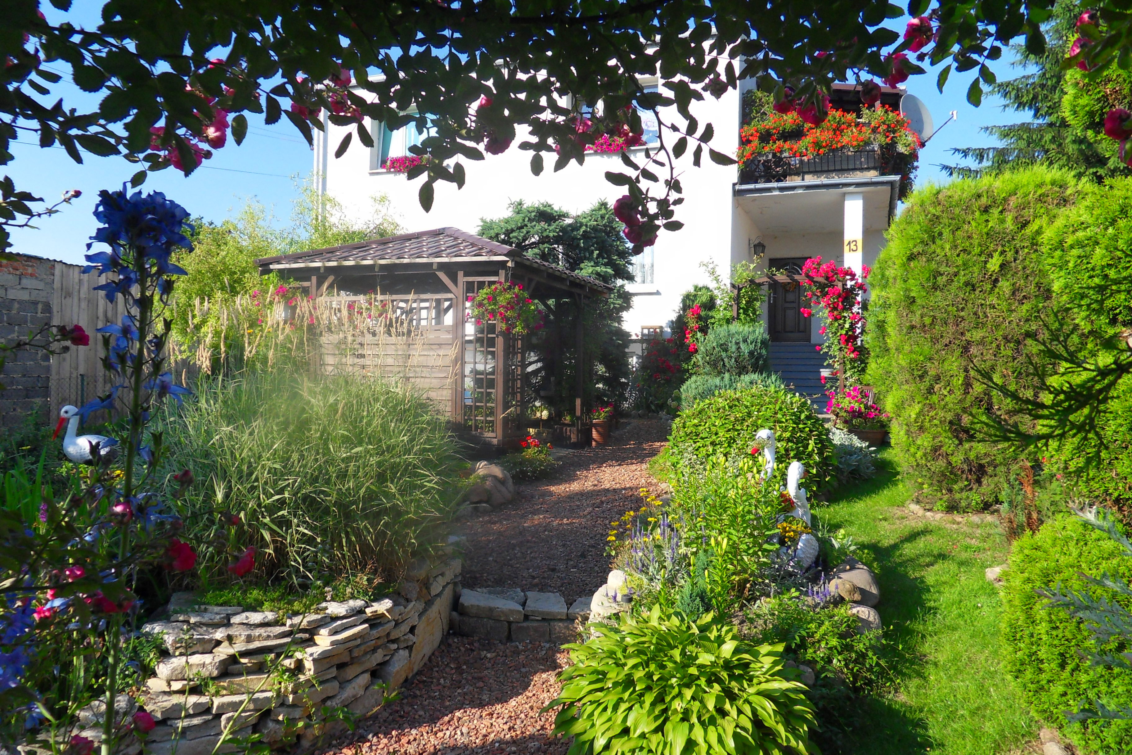 Ścieżka prowadząca przez cały ogród aż do wejścia do domu. Została zrobiona z potłuczonych cegiel, po bokach utworzyłam skalniaki oraz posadziłam ozdobne drzewka.