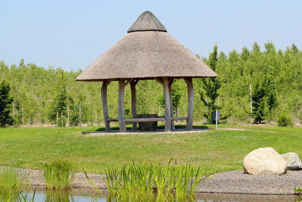 Altana z opa­da­ją­cym ku wo­dzie trzci­no­wym da­chem