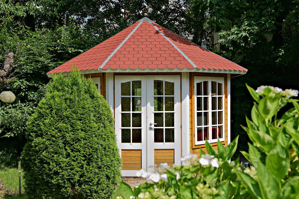 Drew­nia­na bu­dow­la idealnie wta­pia się w kra­jo­braz ogro­du, two­rząc idealne miej­sce let­nich spo­tkań to­wa­rzy­skich