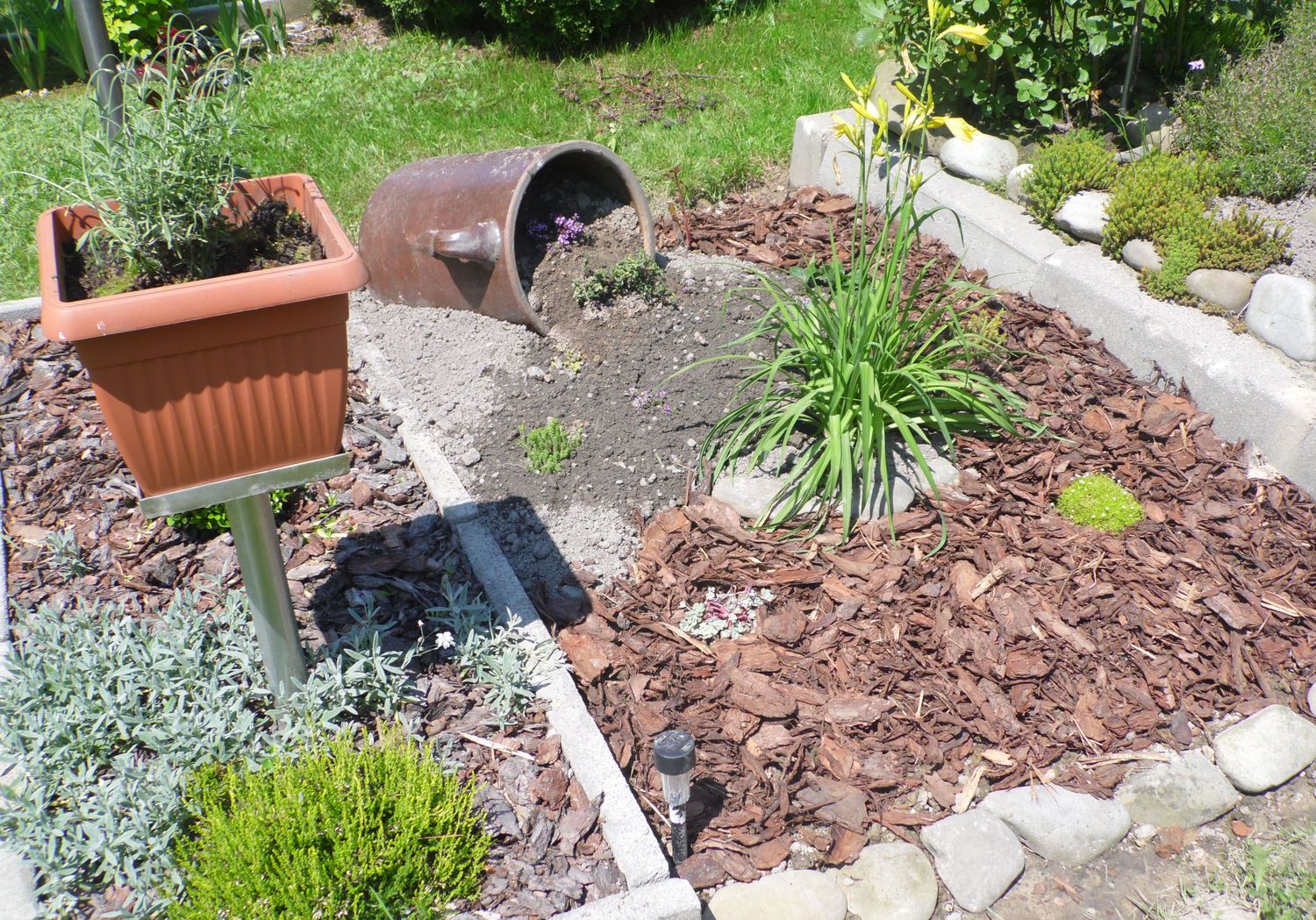 Stare garnki gliniane wkomponowane w ogrodzie