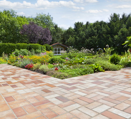 Trawnik przed domem można zastąpić łatwą w utrzymaniu nawierzchnią z płyt lub kostki