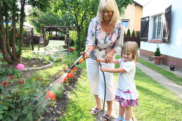Moja mama pokazuje wnuczce, jak pielęgnować kwiaty