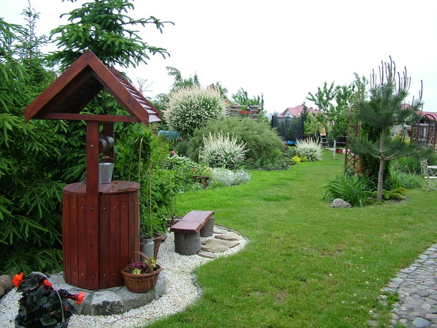 Widok, ukazujący się naszym oczom po przejściu pod pergolą, (która widoczna jest na pierwszym zdjęciu) własnoręcznie wykonana studnia i dalsza część ogrodu