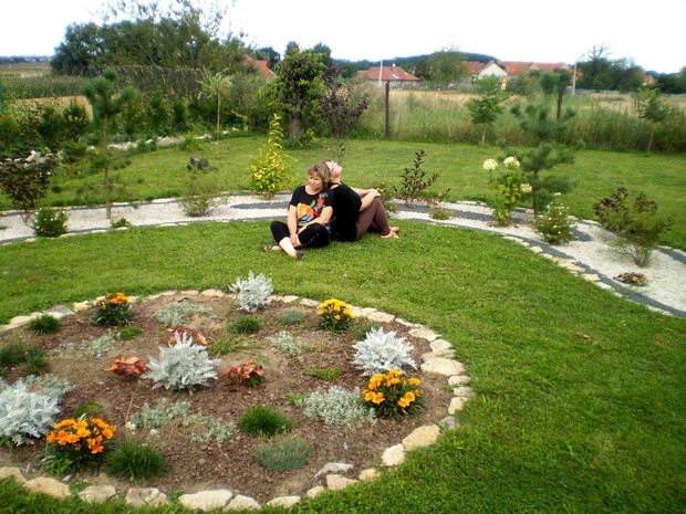 Z mamą w nowym zakątku w ogrodzie - rabacie z bylin i roślin sezonowych oraz w tle rabaty z krzewów ozdobnych sosen i śliwowiśni