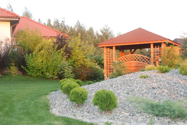 z tyłu domu znajduje się rabata z iglakami i obszerna altana do spotkań rodzinnych