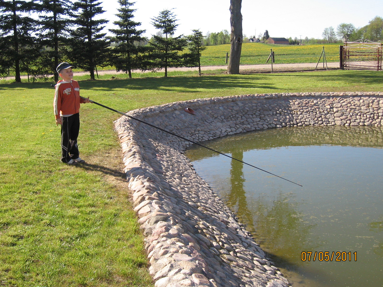 Synek Pawełek łowi ryby w przydomowym stawie