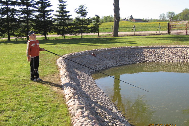 Synek Pawełek łowi ryby w przydomowym stawie