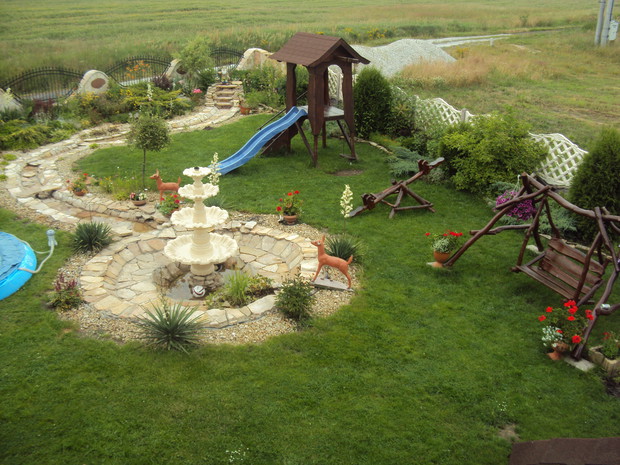 W całej okazałości oczko wodne z fontanną i strumykiem oraz  miejsce zabawy dla dzieci.