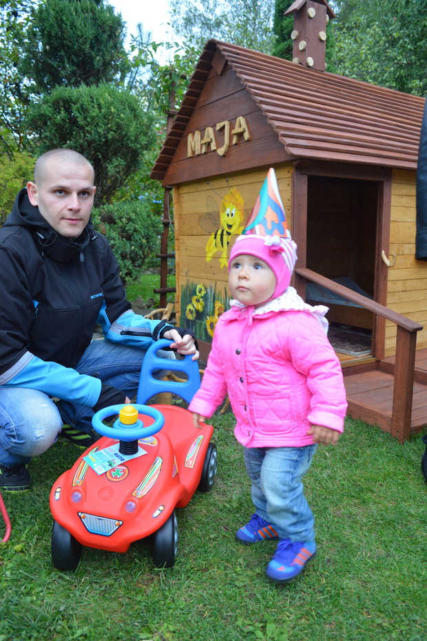 Drewniany ręcznie robiony  domek stojący pośród zieleni ,to prezent na pierwsze urodziny naszego maluszka.