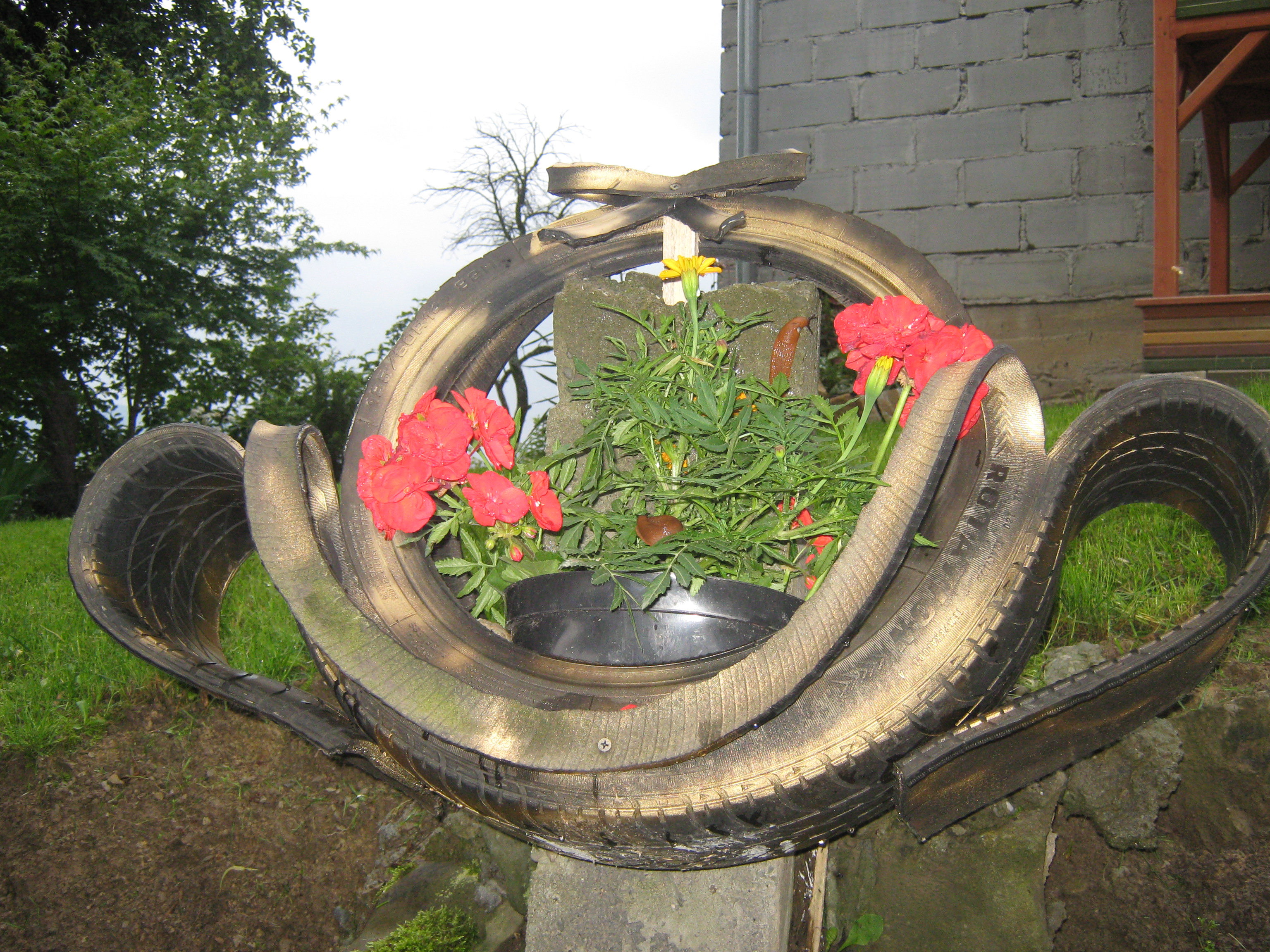 Zużyta opona. Parę cięc boschem , puszka farby w sprayu i przepiękna donica kosz na kwiaty.