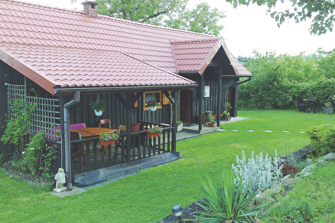 Ażurowa ściana tarasu pełni funkcję pergoli. Pną się po niej moje ulubione powojniki.
