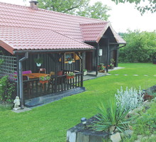 Ażurowa ściana tarasu pełni funkcję pergoli. Pną się po niej moje ulubione powojniki.