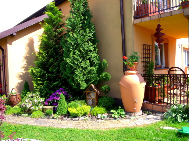 Kącik z domkiem dla owadów i beczką na deszczówkę 