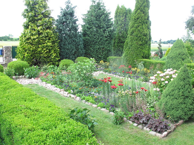 ogród pełen kwiatów róż, lili,turków,mieczyków,astrów,cyni,piwoni,jukki,