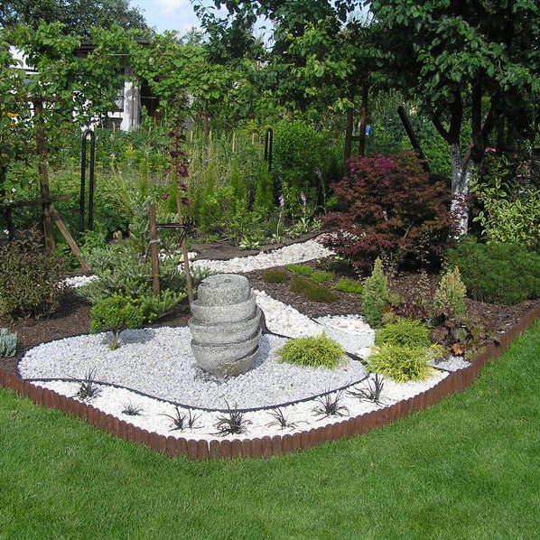 Granitowa fontanna w otoczeniu konwalników japońskich, cyprysików groszkowych, żurawek i świerków białych "Daisy,s White". W tle piękny klon palmowy "Atropurpureum". Z lewej strony fontanny bukszpan formowany.Wiosną kwitną tutaj białe krokusy, tulipany,