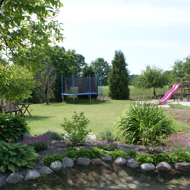 Klomb, który jest często przerabiany. W tle plac zabaw dla dzieci.