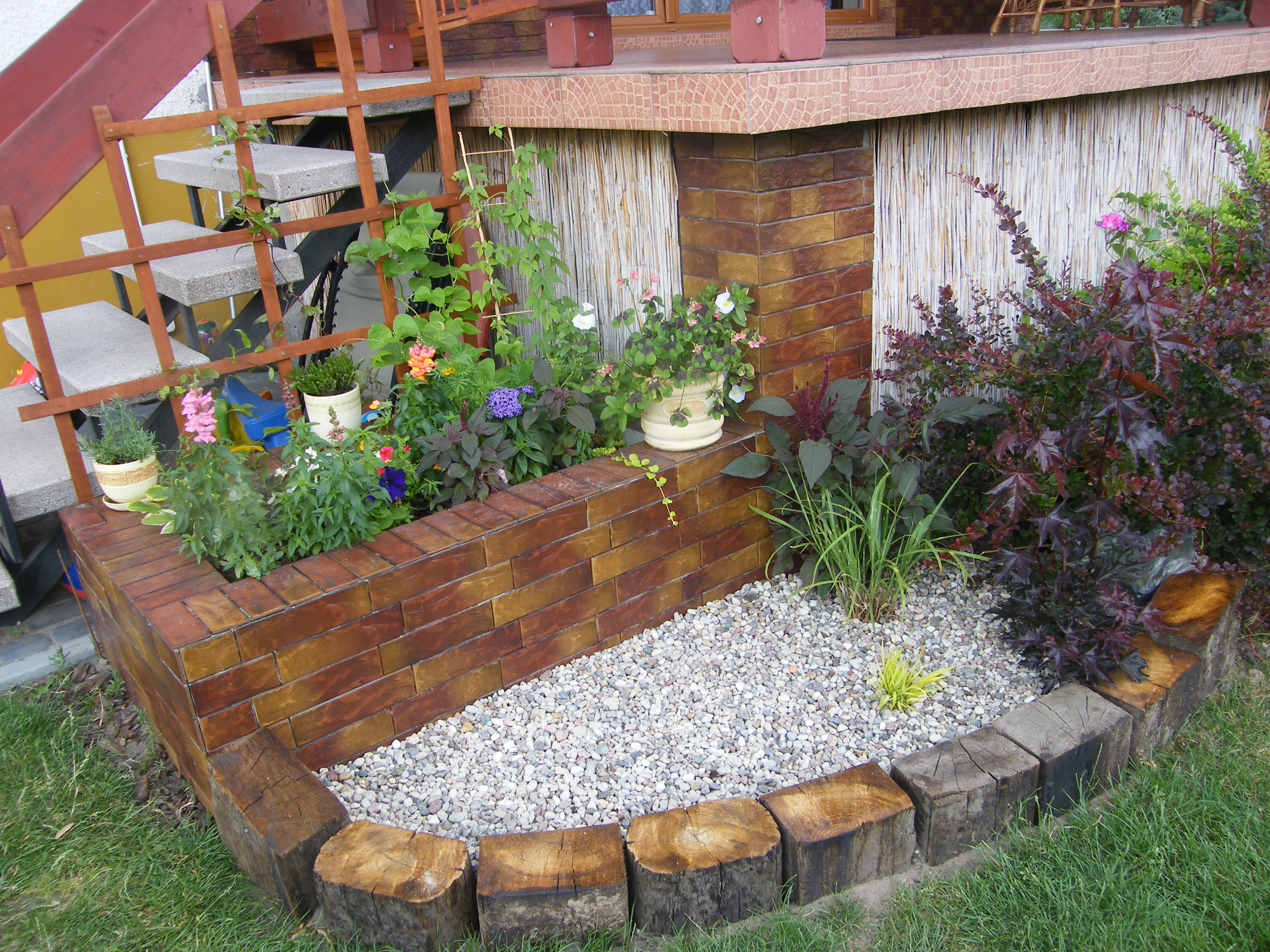 donica przy tarasie z 2 powojnikami i przróżnymi kwiatami