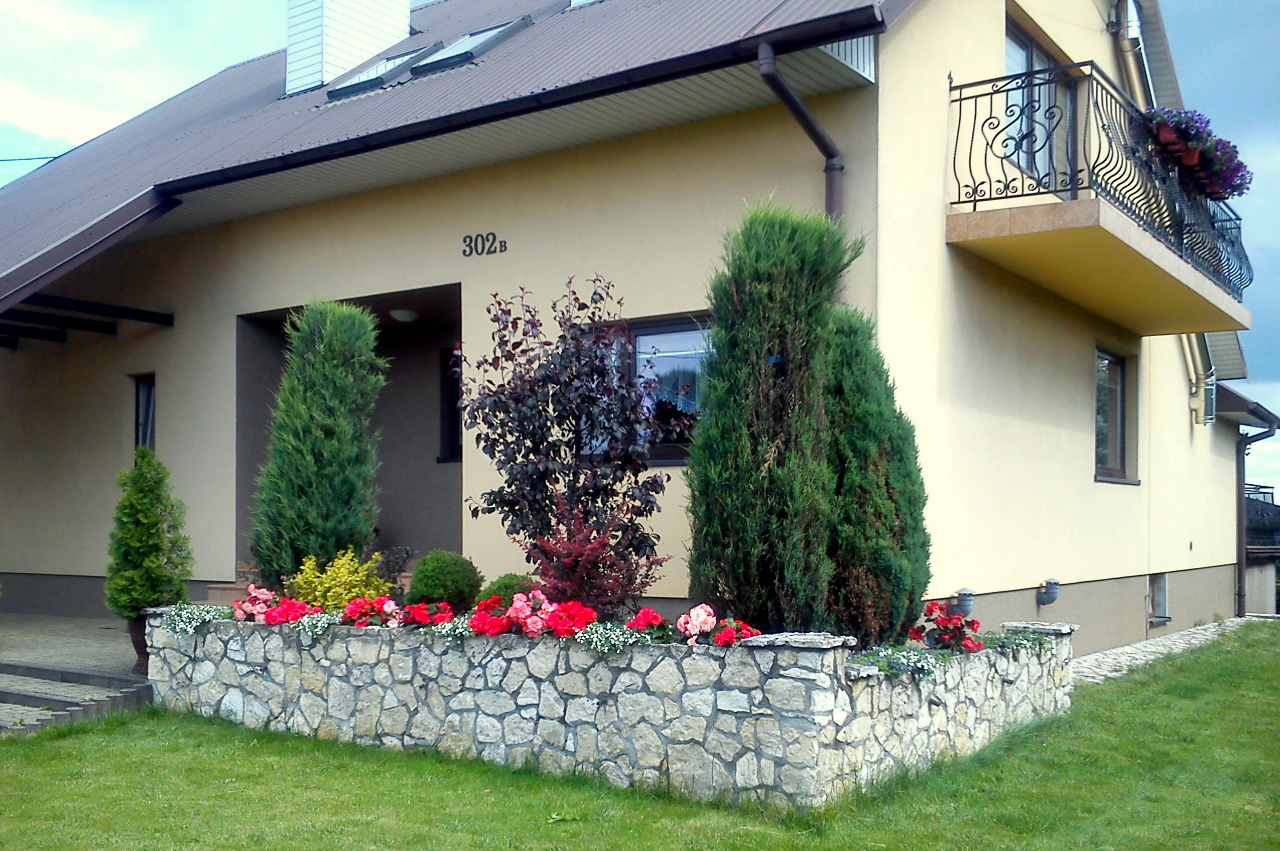 Od frontu gości witają piękne różowe i biało-różowe begonie.