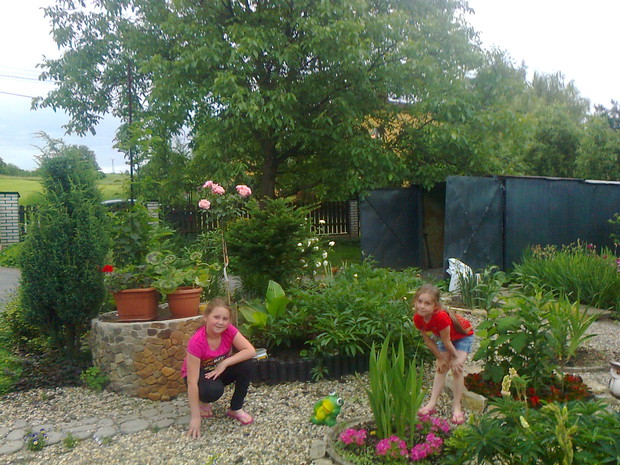 Oliwka i Paulinka na tle studni którą sama obłożyłam kamieniami