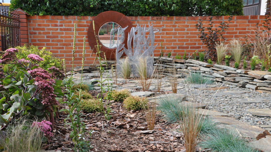 Ceglane ogrodzenie w sąsiedztwie roślinności