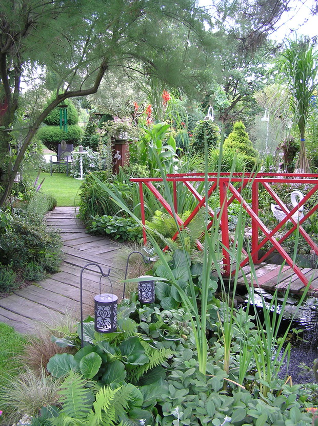 dróżka prowadzi wzdłuż oczka do zakątka ogrodu